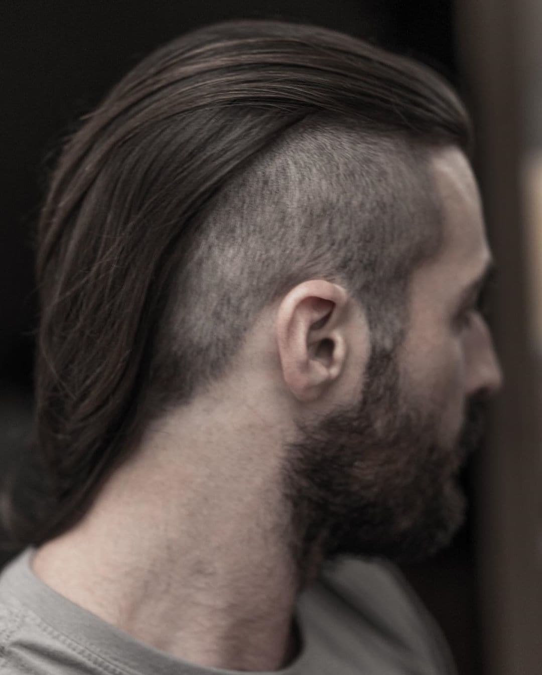 A high-shaved back and sides with longer hair on top creates a striking look