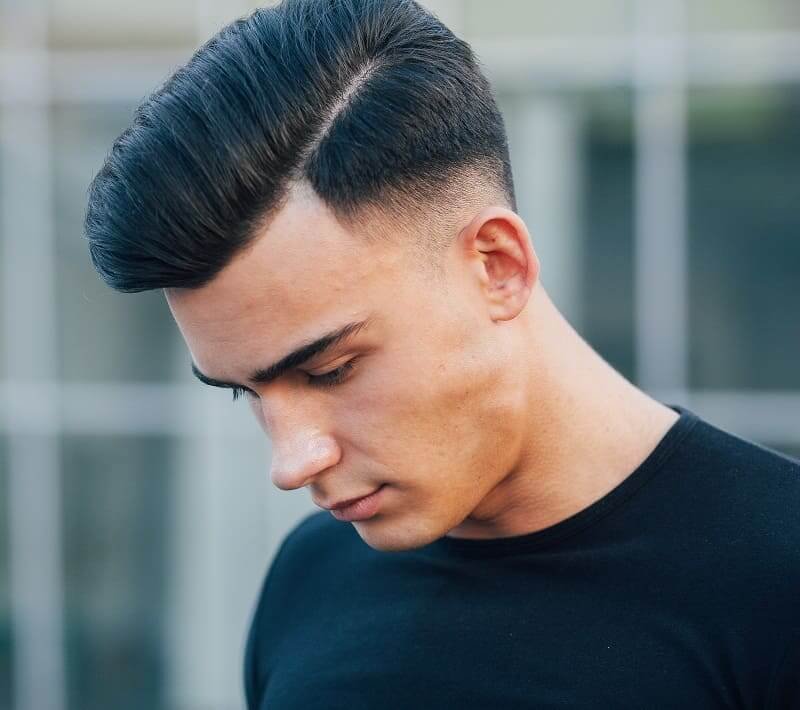 Smoothly combed pompadour hairstyle with shaved sides for a polished appearance
